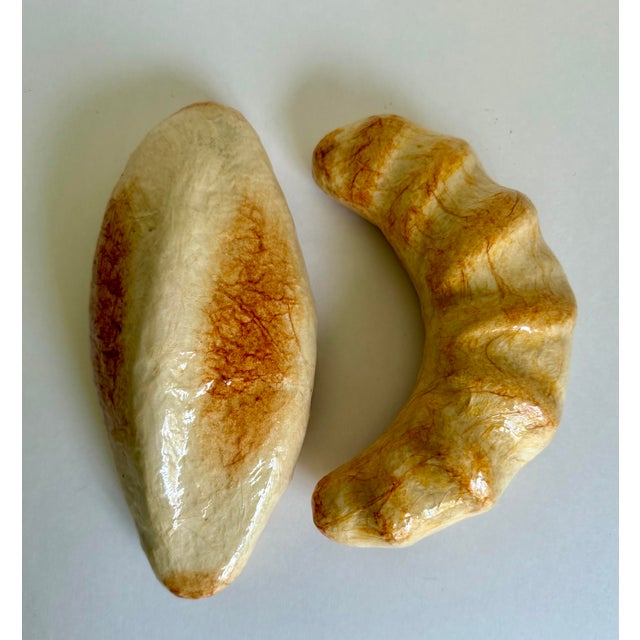 Here is a charming pair of vintage faux bread display pieces featuring a rustic oval roll and a crescent-shaped roll....