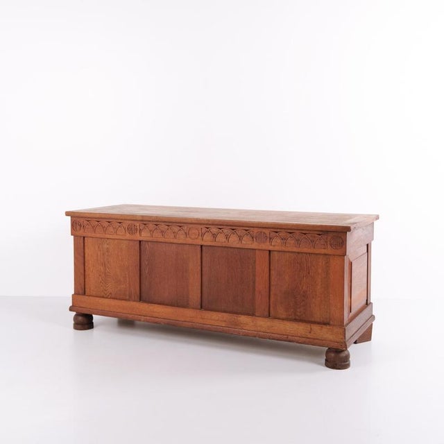 Chest from the 1920s, crafted in oak with decorative carved details and round legs. Offers spacious storage and features...