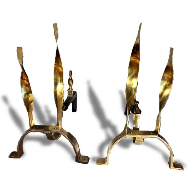 A sparkling pair of gold metal andirons featuring double flame finials. No makers Mark. Dimensions: 12″w x 16″ Condition:...