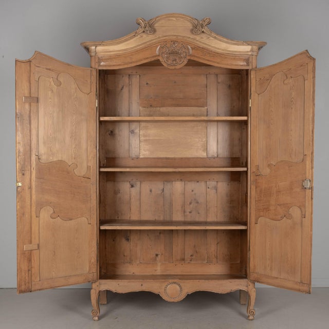 A 19th century Louis XV French Armoire Cauchoise from Caux in Normandy. Made of pine with fine hand carving throughout,...