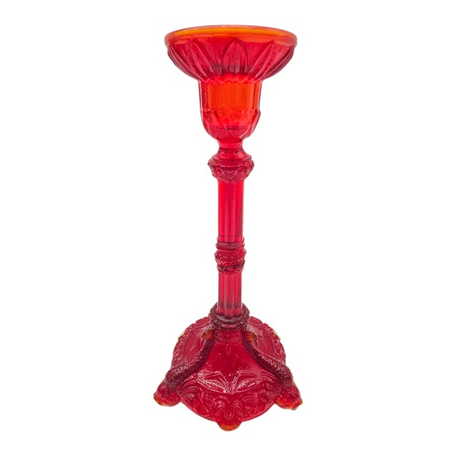 It rises like something out of a fable, molded in ruby fire and baroque restraint. Three dolphins dive downward, captured...