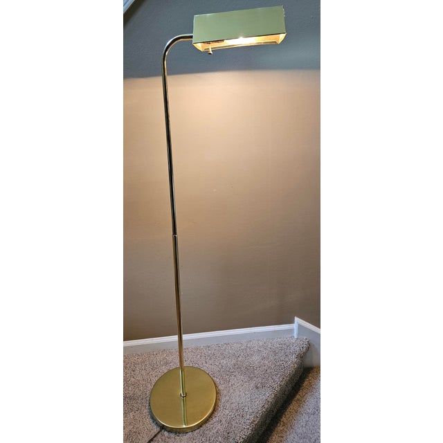 A classic Mid-Century Modern adjustable, telescoping brass pharmacy floor lamp with a triangular brass shade that pivots...