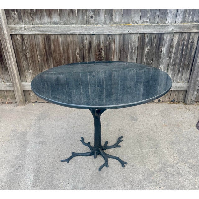 Contemporary dining table by Global Views. The "Faux Bois" table features an iron tree-like base with a black/gray granite...
