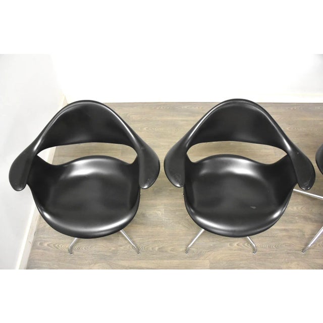 A set of four mid century modern black “Swag” dining chairs designed by George Nelson for Herman Miller. Polished chrome...