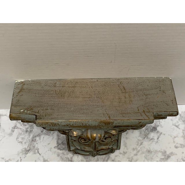 Vintage ornate wall decor accent or shelf made of plaster and aged with a sheen of patina on gray.