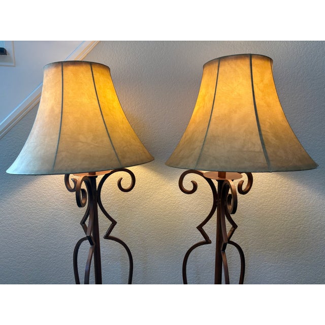 Make a dramatic statement with this striking matched pair of vintage Spanish Revival wrought iron floor lamps, featuring...