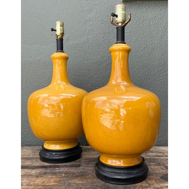 This vibrant pair of table lamps features a classic bottle silhouette, finished in a high-gloss mustard yellow glaze that...
