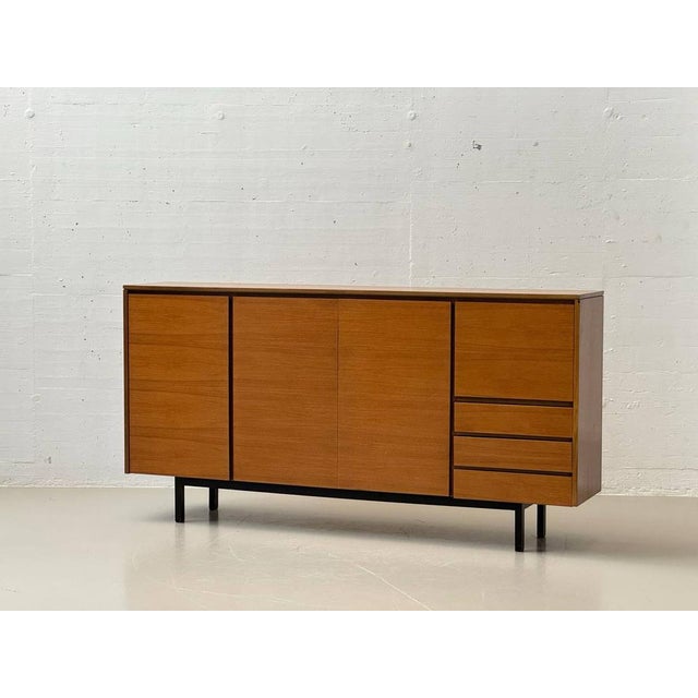 A large swiss mid-century highboard from the 1960s with clean, architectural lines and balanced proportions. The warm,...