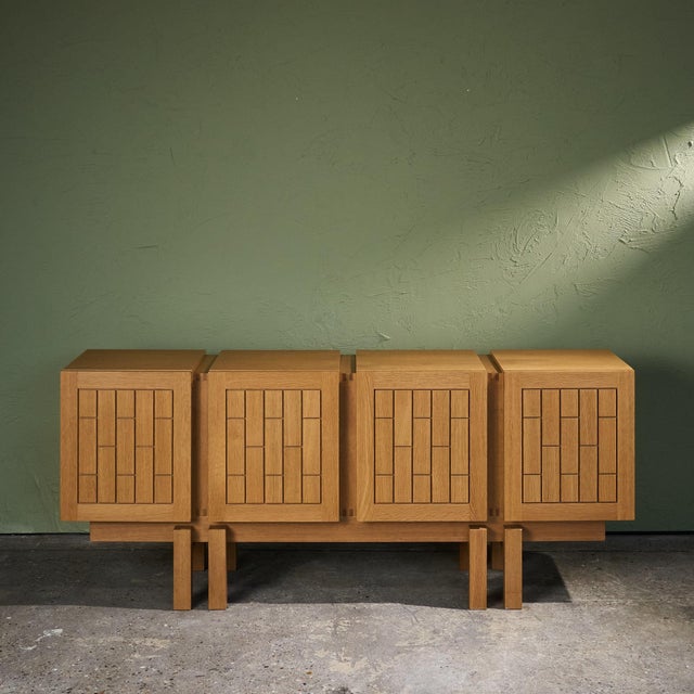 This solid oak graphical sideboard dates to the 1980s. It has four doors with carved patterns applied to both the exterior...