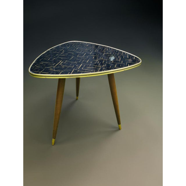 An original, triangular side table from the mid-century modern era. It features a very interesting design with a...