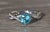 The El Cajon Pariaba Engagement Ring in Platinum. The ring centers on a 1.10 carat vivid very slightly greenish-Blue...