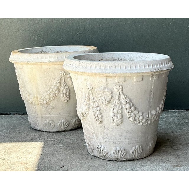 Adorned with classical architectural motifs, this pair of vintage cast cement planters features heavy relief-molded fruit...