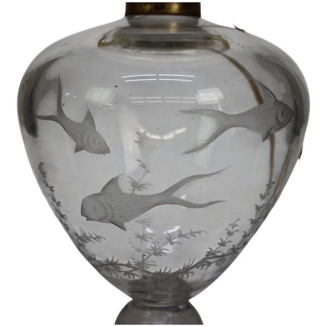This antique table lamp, dating to approximately 1890, features a figural fish etched glass and crystal base. The lamp is...