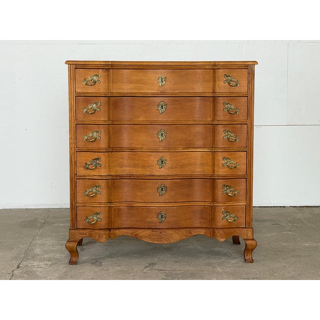 A solid quarter-sawn oak serpentine chest of drawers in the Danish Rococo tradition — the work of an unknown Danish...