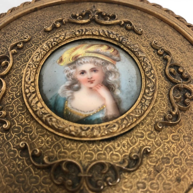 Beautiful circa 1900 French round metal jewelry box with hand painted portrait on porcelain. Lined velvet interior.