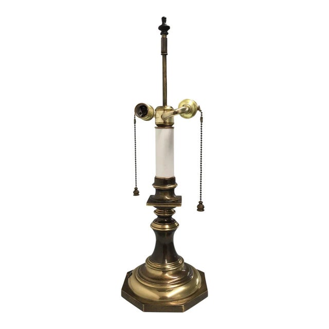 Mid-century brass candlestick table lamp in Vintage bronze finish, with dual bulbs, and brass bell pull strings. Manner of...