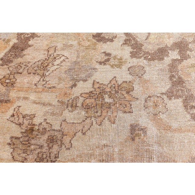 This turn of the century antique Sultanabad rug features an elaborate all-over design of floral abstractions and...