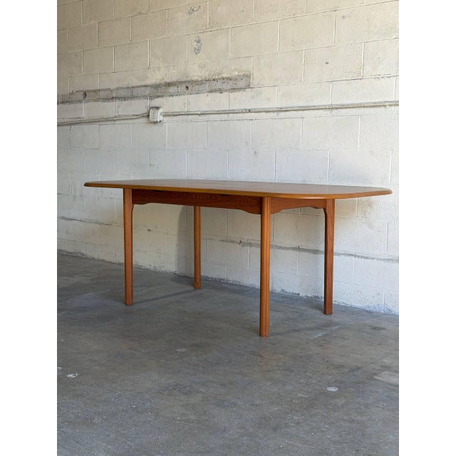 This elegant dining table features an extendable design with a built-in leaf and gently curved edges. The functional form...