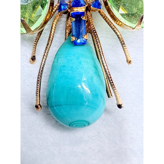 Striking unsigned figural insect brooch, strongly attributed to Schreiner New York, circa 1950s-1960s. This vibrant design...