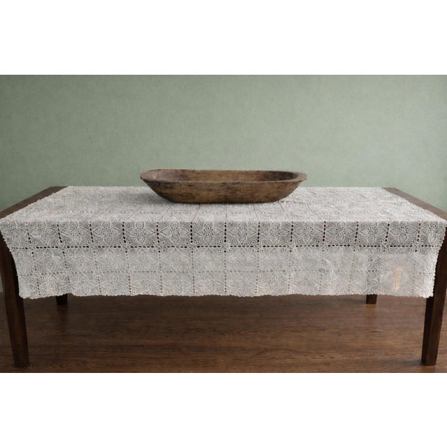 A beautifully handcrafted vintage crochet lace tablecloth in soft ivory cotton, featuring repeating floral medallion...