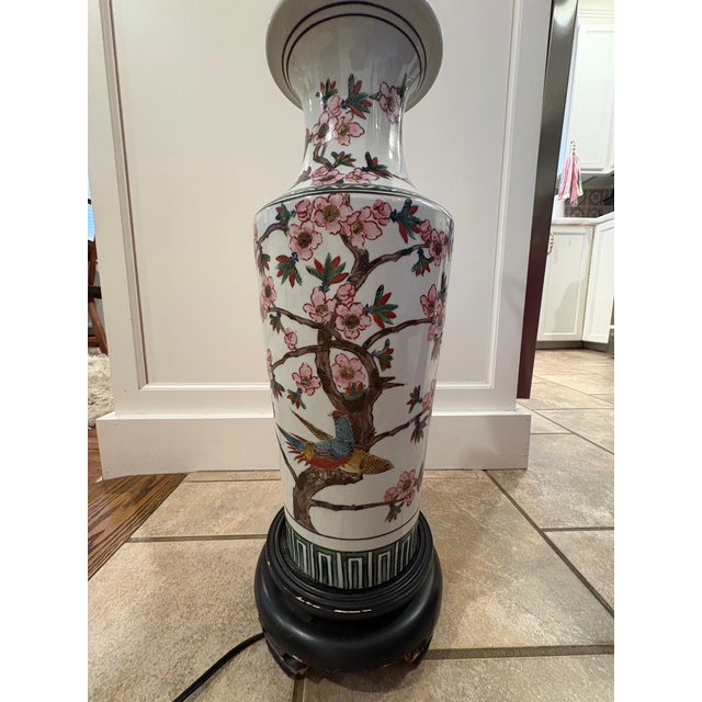 Vintage mid-20th century lamp featuring hand-painted Chinese porcelain base on a black lacquered wood stand. The porcelain...
