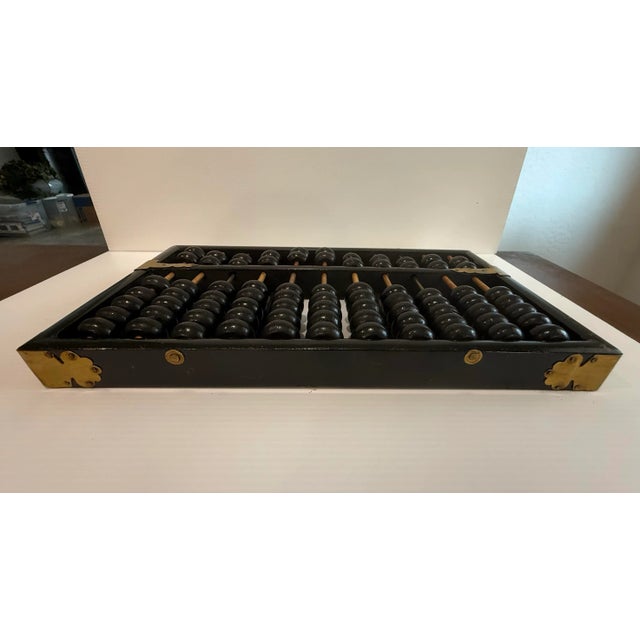 This vintage Lotus-Flower Brand Chinese suanpan abacus is both a fascinating historical object and a striking decorative...