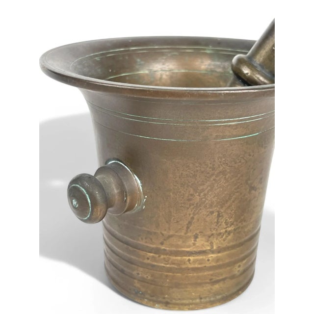 A 19th Century bronze mortar and pestle originating from England. In 19th century England, bronze mortars and pestles were...