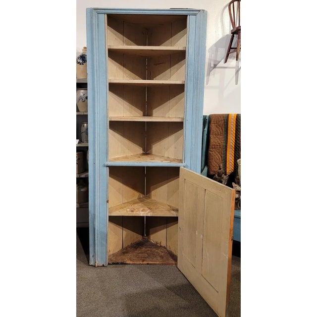 18Thc Original powder blue paneled narrow corner cupboard with picture frame molding.The original cram colored interior...