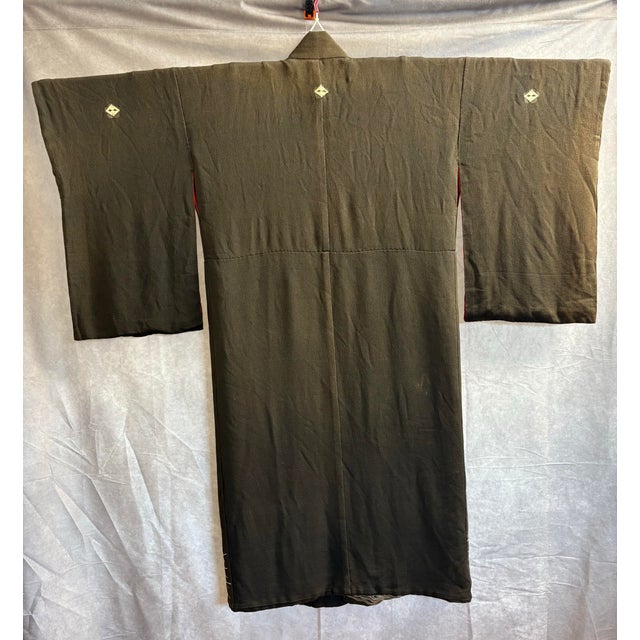 A museum-quality black chirimen kurotomesode from the Meiji or Taisho period, featuring exceptional hand-embroidery and...
