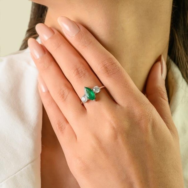 This elegant three-stone engagement ring features 1 marquise cut emerald totaling 0.93 carats, set in rich 18k white gold....