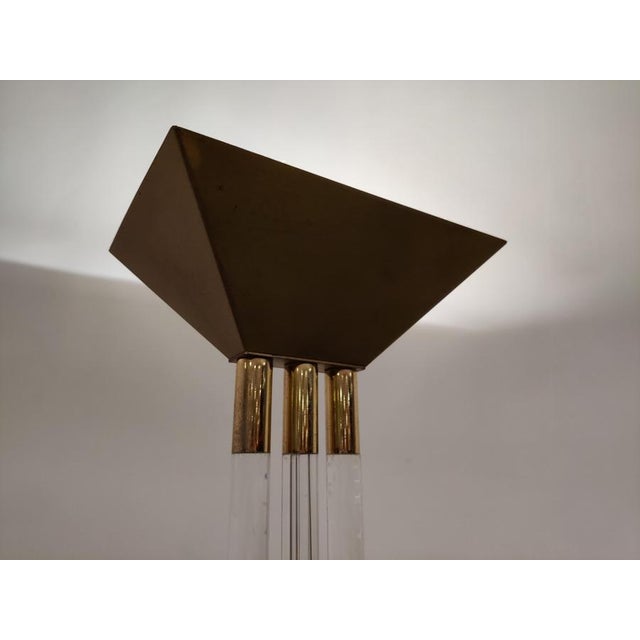Hollywood Regency acrylic glass and brass floor lamp. This elegant floor lamp consists of thee acrylic glass legs and a...