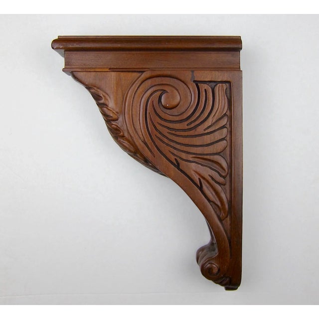 A cherry wood corbel bracket of deep reddish-brown, carved with Neoclassical acanthus leaf decoration in relief. This...