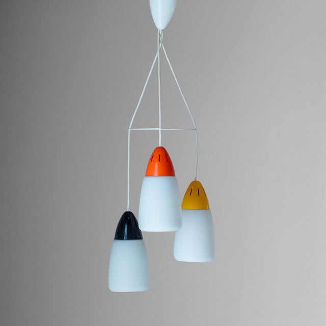 An elegant and eclectic 1970s vintage three-light pendant chandelier, showcasing a strong Postmodern aesthetic that draws...