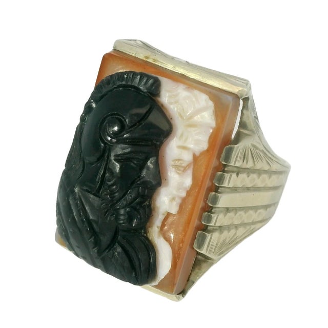 This striking 10K yellow gold men's ring features an intricately carved layered shell and onyx cameo, depicting the busts...