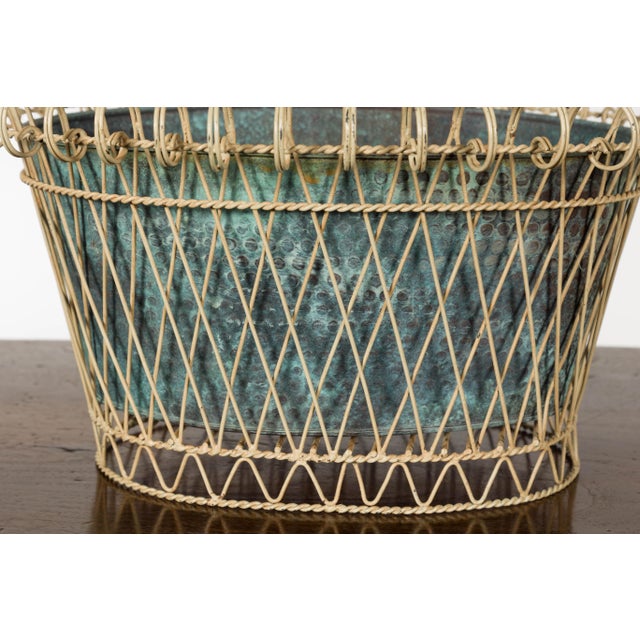 A rustic French oval shaped cachepot from the midcentury period with white painted metal frame surrounding a blue green...