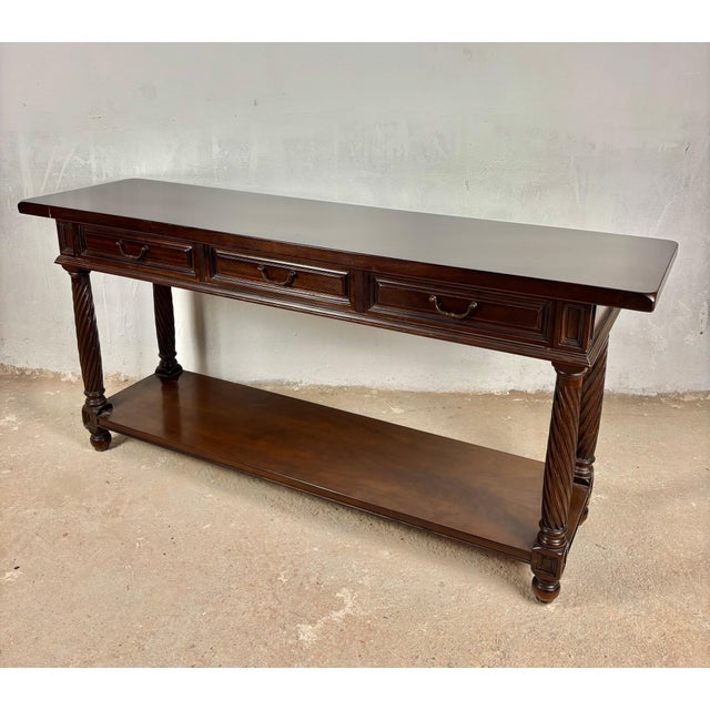 Elegant 1930s Spanish console table crafted in walnut with a warm rich patina. The piece features three drawers across the...