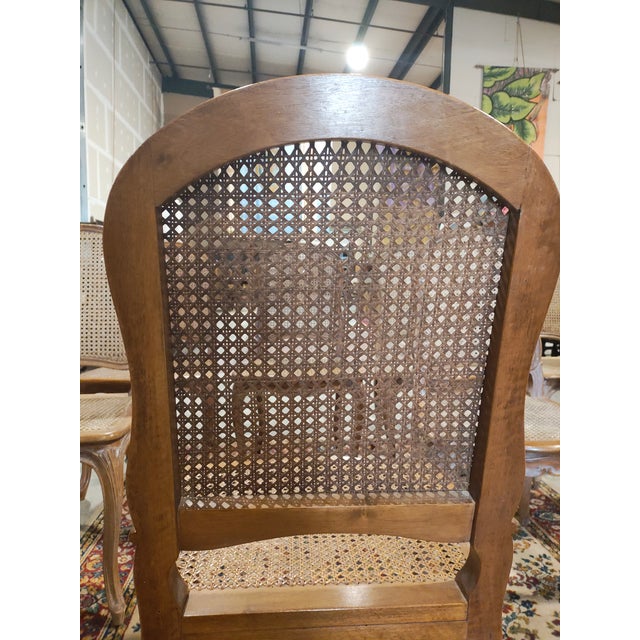 Elegant and timeless set of eight French Louis XV style dining chairs featuring classic balloon backs, hand-caned seats...