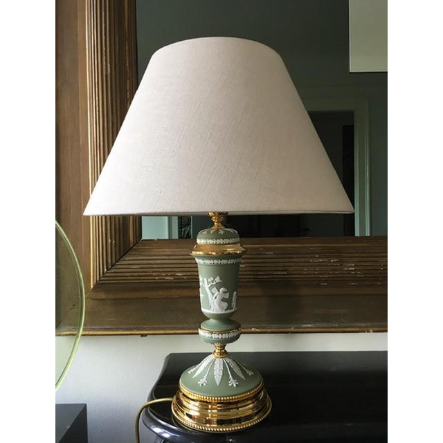 This elegant and glamorous table lamp in light green porcelain and brass, is one of the latest pieces manufactured by a...