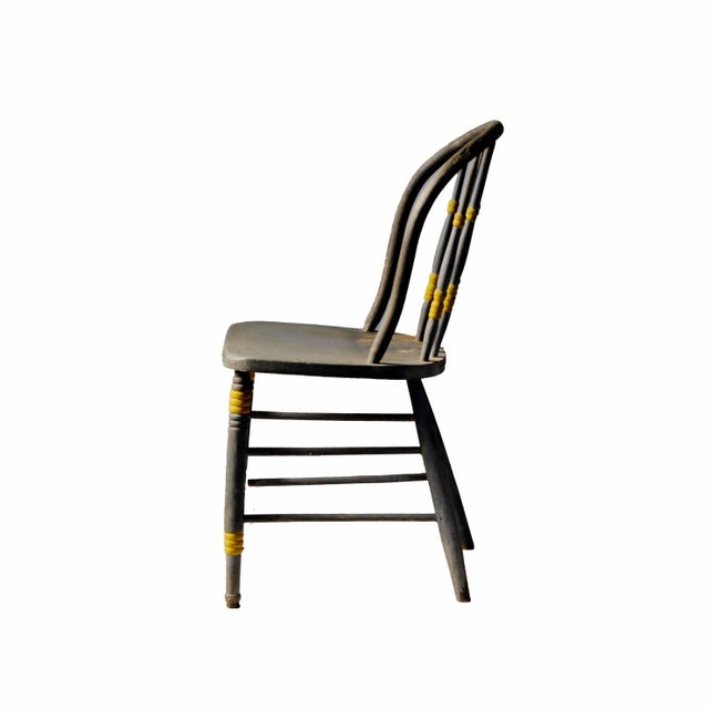 Antique painted bow-back Windsor chairs. Traditional Windsor chairs feature rounded wooden frames anchored by vertical...