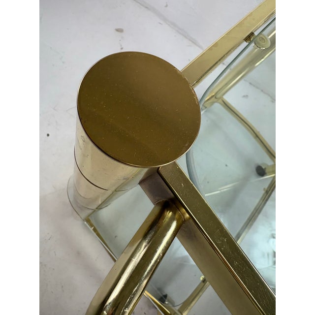 This is a mid-century vintage modern brass and glass bar trolley by design Institute of America. This beautiful modernist...