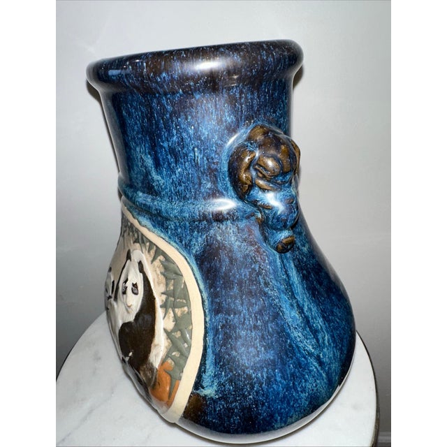 Ceramic vases featuring hand-painted panda panels set within a bamboo landscape. The vases have a deep blue-black high-...