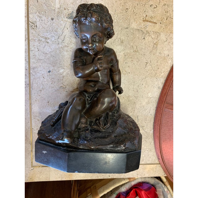This item is a bronze cherub statue, often designed in the style of 19th-century French sculptor Claude Michel Clodion....