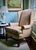 This handsomely designed wingback chair is covered in a geometric print that is subtle because of its neutral color...