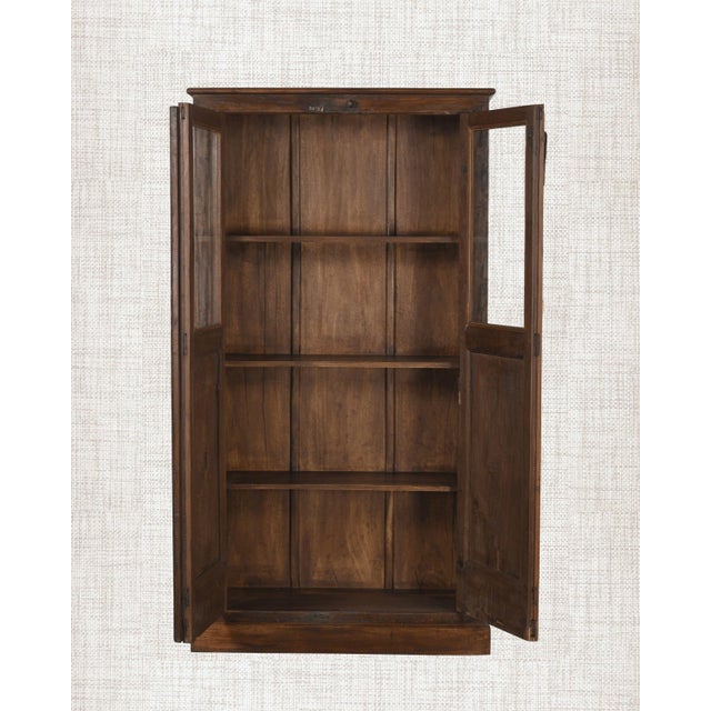 A cabinet made for display. Full glass-panel doors spanning the entire height, four interior shelves, and a ball-foot base...