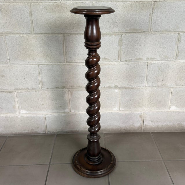 Slender and elegant solid wood floor-standing pedestal column with a twisted Solomonic column design, a refined piece of...