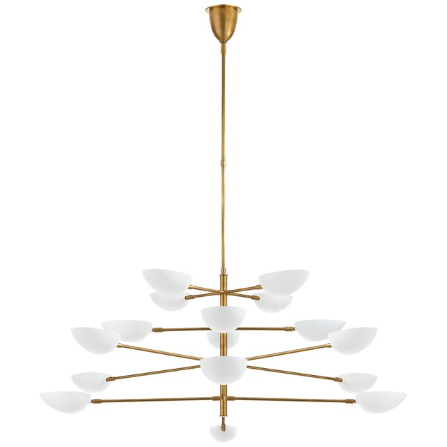 Graphic Grande Four-Tier Chandelier in Hand-Rubbed Antique Brass with White Shades Designer: AERIN Fixture Height: 28.25"...