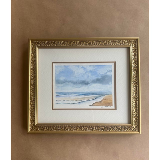A serene original watercolor capturing the gentle rhythm of waves beneath a moody coastal sky. Painted in soft washes of...