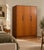 A stylish mid-century G Plan Fresco triple wardrobe in warm teak, featuring three clean-fronted doors, contrasting darker...