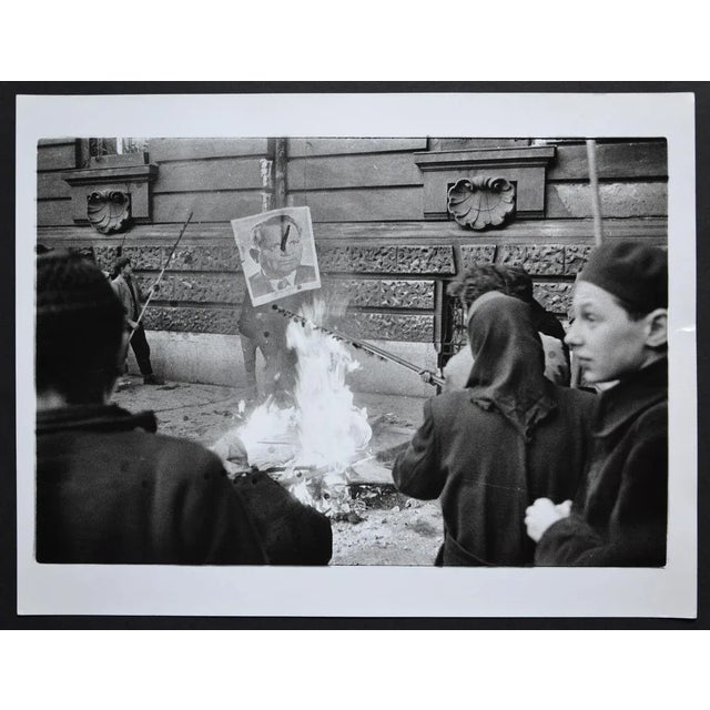 Hungary uprising in back a fire with a poster of Istvan Dobi, 1956. Keywords: Hungary; Hungarian; people; crowd;...