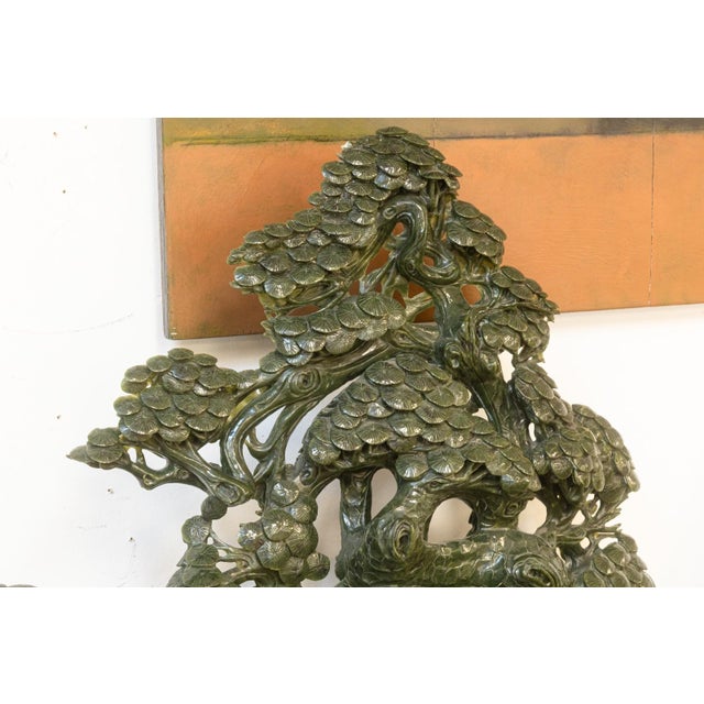 A vintage Chinese sculpture intricately carved from rich green jade, featuring the Taoist deity Shou Lao (symbol of...